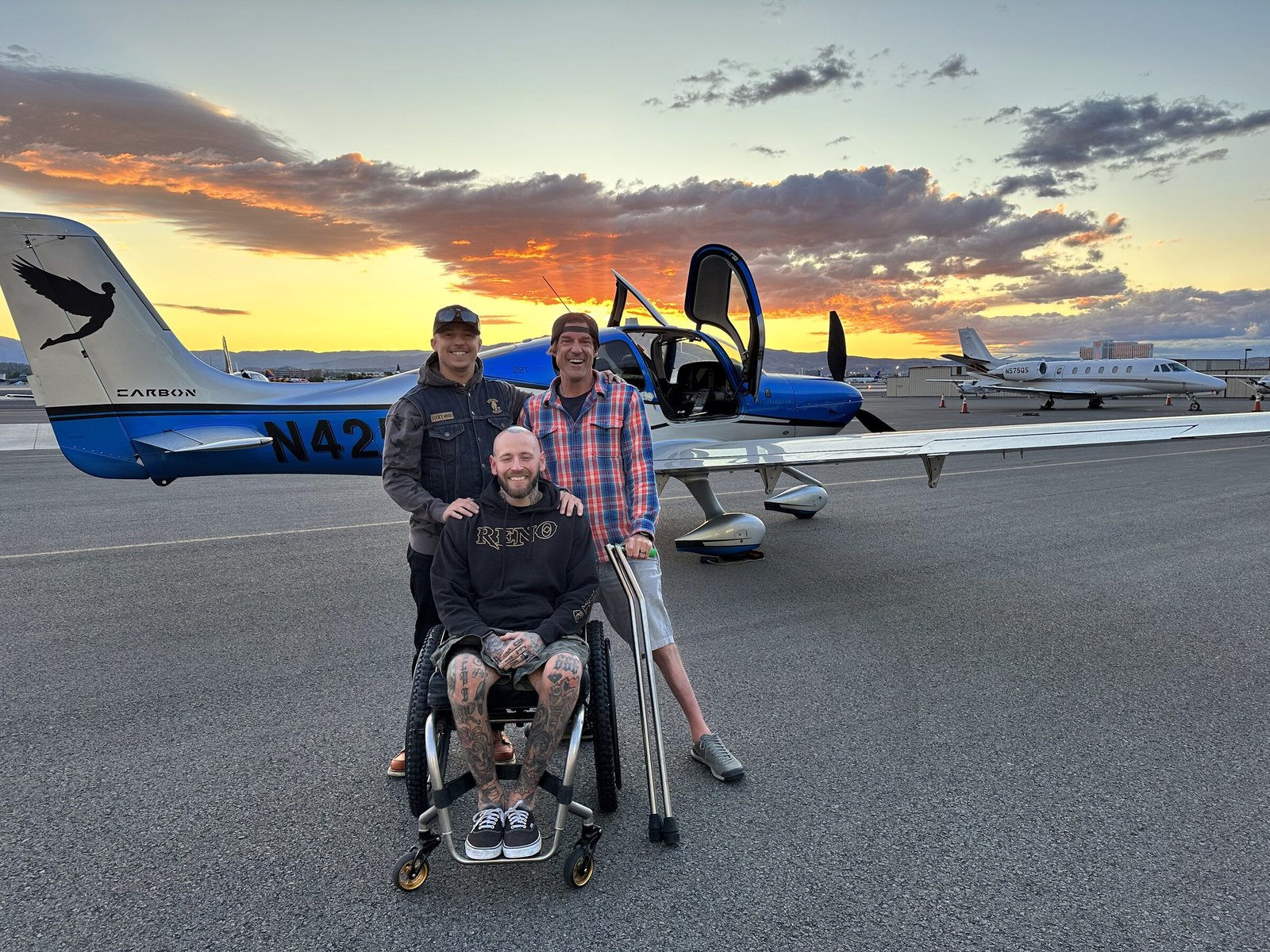 A hero, Grant Korgan, and friend on the tarmac with the Moment Foundation aircraft at sunset